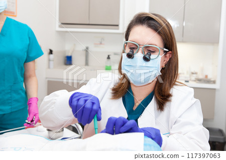 Dermatologist carrying out a skin biopsy on the face of a senior adult patient. Skin lesion removal procedure. Biopsy punch. 117397063