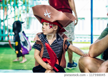 Boy Cat Pirate costume. Halloween party in kindergarten. Aqua makeup painted kids face. Bright festive Boy Cat Pirate costume. Halloween party in kindergarten. Aqua makeup painted kids face. Bright festive 117398045