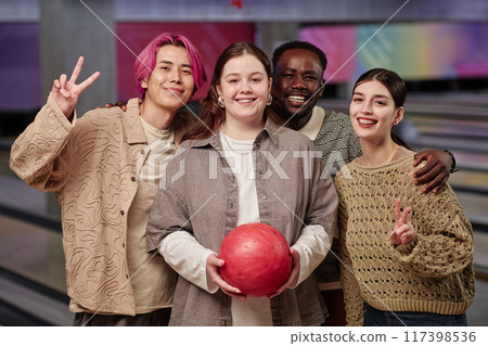 Portrait of diverse group smiling and holding bowling ball at bowling alley celebrating together creating happy memories Portrait of diverse group smiling and holding bowling ball at bowling alley celebrating together creating happy memories 117398536