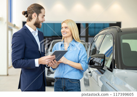 Woman negotiating car purchase with the dealer at automobile store Woman negotiating car purchase with the dealer at automobile store 117399605