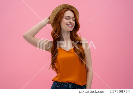 Pretty flirty young woman in straw hat looking contented 117399794