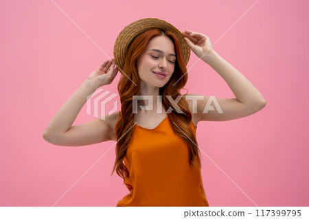 Pretty flirty young woman in straw hat looking contented Pretty flirty young woman in straw hat looking contented 117399795