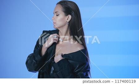 Ballerina in pointe shoes in studio on cube chair in street style posing 117400119