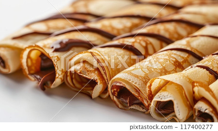 Rolled crepes filled with chocolate spread. 117400277
