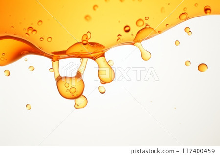 Orange liquid splash with bubbles and drops. 117400459