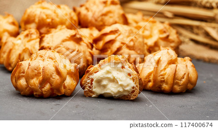 Delicious cream-filled profiteroles, golden and crisp, perfect for a sweet dessert treat Delicious cream-filled profiteroles, golden and crisp, perfect for a sweet dessert treat 117400674