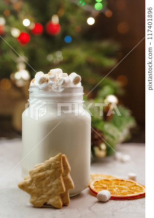 Christmas white drink eggnog with marshmallow on grey background with spruce branches, biscuits and festive bokeh Christmas white drink eggnog with marshmallow on grey background with spruce branches, biscuits and festive bokeh 117401896