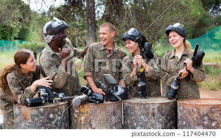 Discussion of team of paintball players on vacation outdoor Discussion of team of paintball players on vacation outdoor 117404470