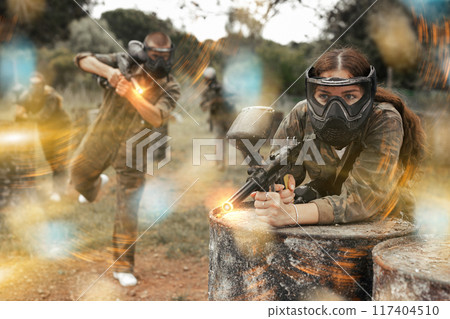 Paintball players of one team in camouflages and masks aiming with gun in shootout playing 117404510