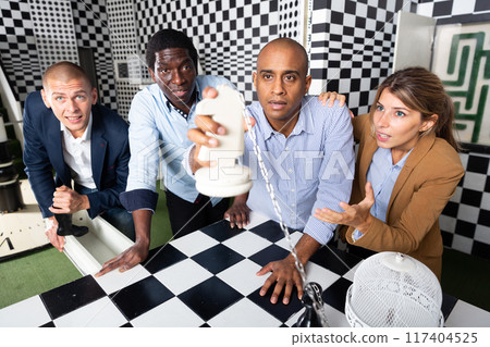 Four friends solving puzzles in quest room 117404525