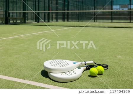 Rackets and balls on paddle tennis court Rackets and balls on paddle tennis court 117404569
