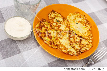 On plate are vegetable pancakes made from grated zucchini On plate are vegetable pancakes made from grated zucchini 117404614