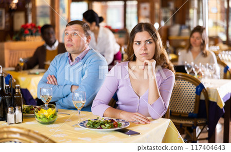 Unhappy couple sitting in restaurant after quarrel during dinner Unhappy couple sitting in restaurant after quarrel during dinner 117404643
