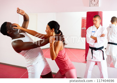 Woman painful eye blow to african american man in self defense training 117404696