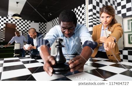 People trying together to find solution of conundrum in quest room People trying together to find solution of conundrum in quest room 117404727