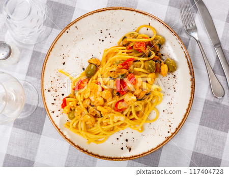 Pasta with seafood and olives served on platter Pasta with seafood and olives served on platter 117404728