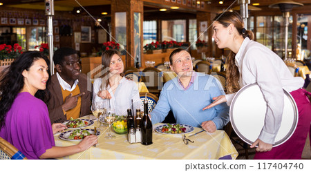 Group of friends makes an order waitress during a dinner in restaurant Group of friends makes an order waitress during a dinner in restaurant 117404740