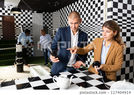 People trying together to find solution of conundrum in quest room People trying together to find solution of conundrum in quest room 117404914