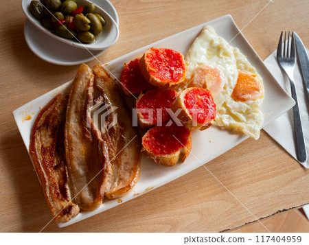 Tasty nutritious breakfast of bacon and scrambled eggs closeup Tasty nutritious breakfast of bacon and scrambled eggs closeup 117404959