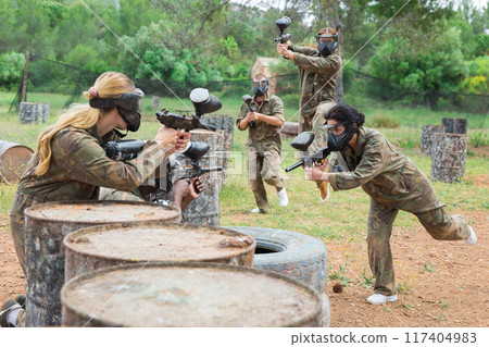 Two active opposing teams with guns playing paintball 117404983