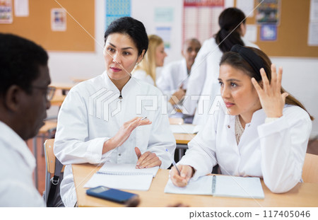 Adult people in white coats working in groups during professional training Adult people in white coats working in groups during professional training 117405046