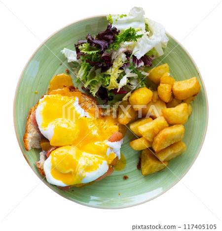 Eggs Benedict with smoked salmon, fried potatoes and greens Eggs Benedict with smoked salmon, fried potatoes and greens 117405105