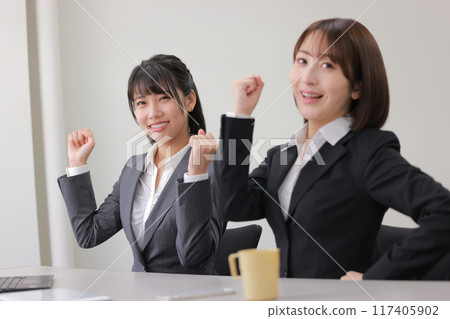 Two businesswomen posing in a fist_1 Two businesswomen posing in a fist_1 117405902
