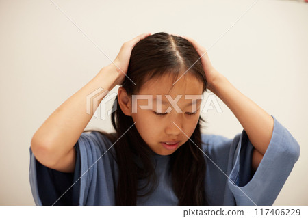 一個暑假的小學生正在為她的作業煩惱 一個暑假的小學生正在為她的作業煩惱 117406229