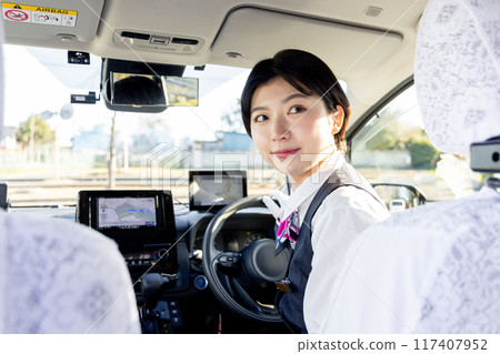 A female taxi driver checking the rear view A female taxi driver checking the rear view 117407952