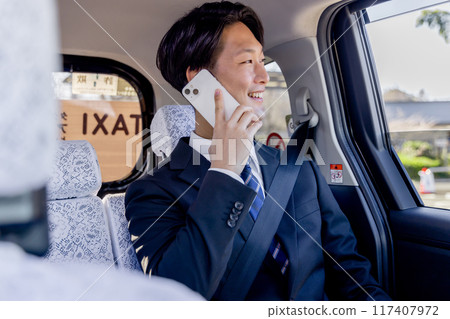 坐在計程車後座上用智慧型手機交談的商人 117407972