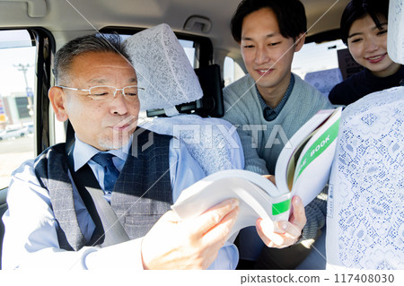 一對夫婦在旅行時在出租車上展示旅遊指南並告訴他們目的地 117408030