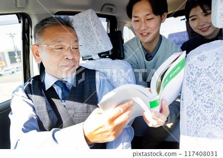 一對夫婦在旅行時在出租車上展示旅遊指南並告訴他們目的地 一對夫婦在旅行時在出租車上展示旅遊指南並告訴他們目的地 117408031