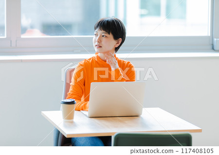 Young woman using laptop in coworking space Young woman using laptop in coworking space 117408105
