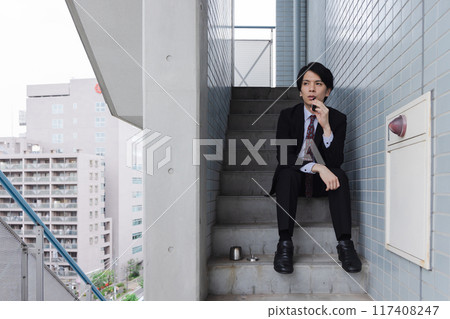 商人在緊急樓梯上抽電子煙 117408247