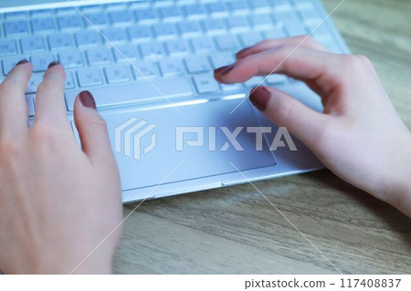 A woman's hand to operate a personal computer 117408837