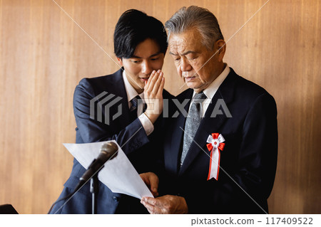 Senior businessman unable to read while giving a speech Senior businessman unable to read while giving a speech 117409522