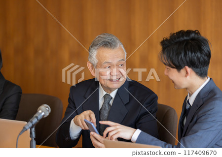 Senior businessman using smartphone during meeting 117409670