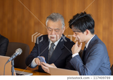 Senior businessman using smartphone during meeting 117409789