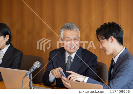 高級商人在會議期間使用智慧型手機 高級商人在會議期間使用智慧型手機 117409906
