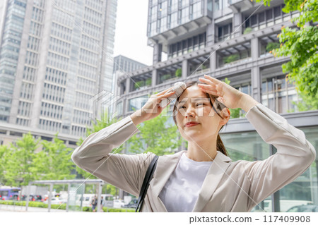 Business woman wiping sweat with a handkerchief Business woman wiping sweat with a handkerchief 117409908