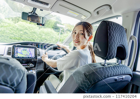 Woman driving, backing up, parking in garage Woman driving, backing up, parking in garage 117410204