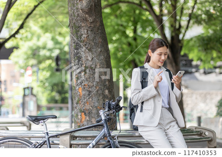 Young woman commuting by bicycle Young woman commuting by bicycle 117410353