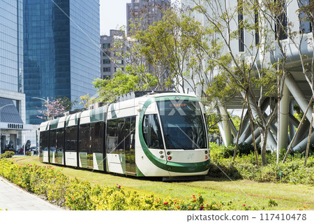 View of the circular light rail train driving past the Glory Pier in Kaohsiung, Taiwan. 117410478
