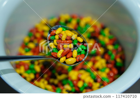 Colorful Sunflower seeds coated with chocolate in a plastic bowl Colorful Sunflower seeds coated with chocolate in a plastic bowl 117410710