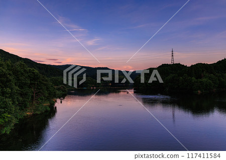 Summer 2024 Evening view of Nunome Dam in eastern Nara City. Sunset on the lake side of the dam. Sky becomes more vivid with high contrast. 117411584