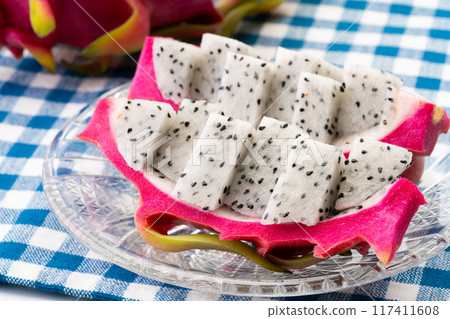 Dragon fruit cut into bite-sized pieces and served on a plate 117411608