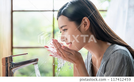 Woman washing her face (AI-generated image) 117412459