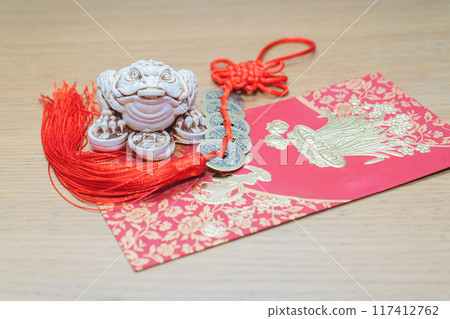 Chinese decoration. Chinese Knot Talisman Copper Coins. Money toad netsuke , red envelope for money. The Chinese word means happiness or good fortune. 117412762