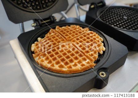 Belgian waffles in a frying pan on a kitchen table. Belgian waffles in a frying pan on a kitchen table. 117413188