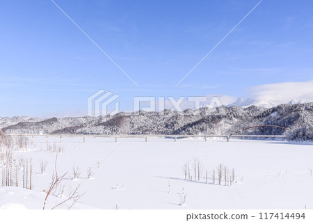Yubari City, Hokkaido, Shiragane Bridge spanning the completely frozen Lake Shuparo and Mount Yubari and Mount Maedake [January] 117414494